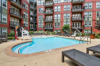 A small pool in front of a red brick building.
